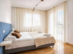 a bedroom with a large bed and large windows at Sa Torre in Llucmajor +18 photos