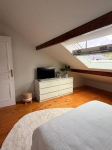 a bedroom with a bed and a tv and a window at Chambre 24h Le Mans in Guécélard