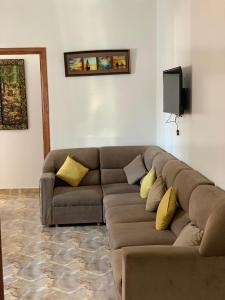 a living room with a brown couch with yellow pillows at Azla Beach Escape - Cozy Apartment in Tétouan
