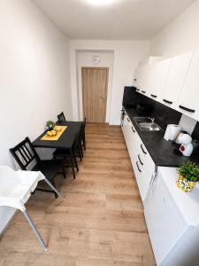 a kitchen with white cabinets and a table with chairs at Centrum apartment in Brno