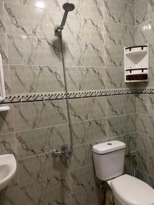 a bathroom with a toilet and a shower at Azla Beach Escape - Cozy Apartment in Tétouan