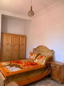 a bedroom with a large bed with a wooden headboard at Azla Beach Escape - Cozy Apartment in Tétouan