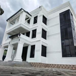 a white building with windows on a cloudy day at Villaveh Gameview in Nakuru