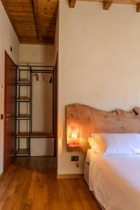 a bedroom with a bed and a wooden headboard at Il Carro Rooms - Monza Centro, Tribunale, Ospedale in Monza