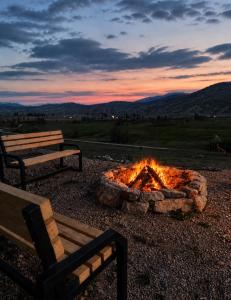 a fire pit with two benches in front of it at Forest Panorama Cabin Brezna in Plužine