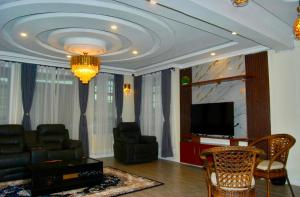 a living room with a couch and a television at Villaveh Gameview in Nakuru
