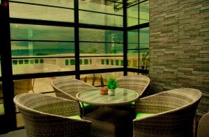 a table and chairs in a room with a window at Villaveh Gameview in Nakuru