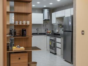 a kitchen with white cabinets and a stainless steel refrigerator at Pool view- Luxurious 3BD Hotel Apt, Sheikh Zayed in Kafr Abū ʼumaydah