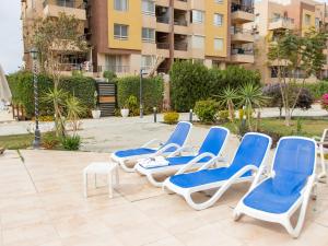 a group of lounge chairs sitting on a patio at Pool view- Luxurious 3BD Hotel Apt, Sheikh Zayed in Kafr Abū ʼumaydah