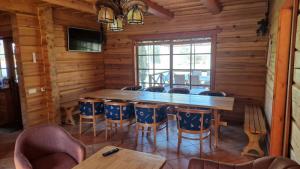 a dining room with a wooden table and chairs at Aido ir Vido sodyba in Utena