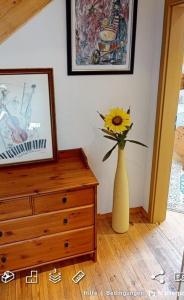a vase with a sunflower sitting on top of a dresser at Dia Mare Taubenschlag in Ueckeritz