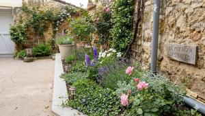 a garden with flowers and a sign on the side of a building at Charming house in Montbron