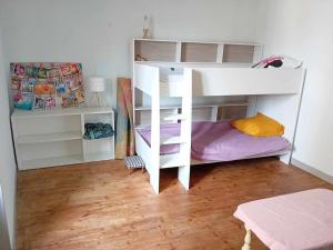 a white bunk bed in a room with a wooden floor at Charming house in Montbron