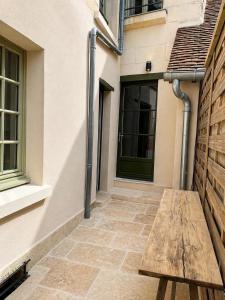a wooden bench in front of a building at Casa Terracotta in Saint-Aignan