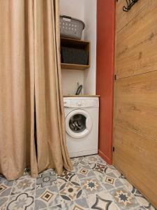 a laundry room with a washing machine and a curtain at Casa Terracotta in Saint-Aignan