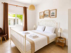 a bedroom with a white bed and a window at Sophia House in Keramoti +10 photos