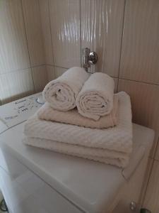 a stack of towels sitting on top of a toilet at Apartmani, prenoćište Ana in Tomislavgrad