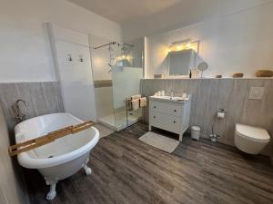 a bathroom with a tub and a sink and a toilet at Maison des Ingénieurs in Molières-sur-Cèze +34 photos