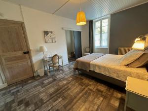 a bedroom with a bed and a wooden floor at Maison des Ingénieurs in Molières-sur-Cèze