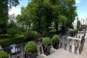 uma varanda com vasos de plantas numa rua da cidade em London House Hotel em Londres