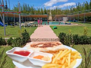 a plate of food with french fries and a pool at Villa Sun and Chill, Ferme d'hôtes familiale avec piscine animée, restaurant et jardin près de Safi in Safi