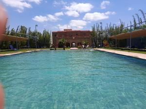 a large pool of water in front of a building at Villa Sun and Chill, Ferme d'hôtes familiale avec piscine animée, restaurant et jardin près de Safi in Safi