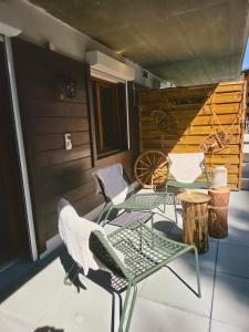 a patio with chairs and a table on a porch at Nendaz Nest - Appartement moderne & confortable au cœur de Nendaz - 4 Vallées in Nendaz