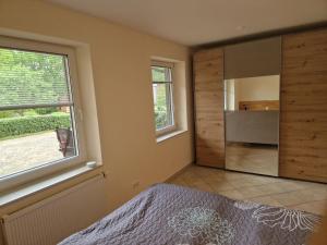 a bedroom with a large window and a large mirror at Gartentraum in Papenburg