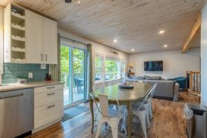 a kitchen and living room with a table and chairs at Diamond Lakehouse | SUP, Canoe, BBQ, Aurora Magic in Highland Grove