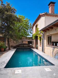 a swimming pool in front of a house with a bridge at Casa rural con piscina cubierta en Segovia - Viento de Ladera in Segovia