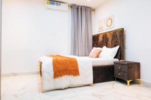 a bedroom with a bed with an orange and white blanket at Amber in Tema