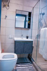 a bathroom with a toilet and a sink and a mirror at Amber in Tema +46 photos