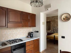 a kitchen with wooden cabinets and a stove top oven at Antica Interamnia in Teramo