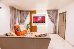 a living room with a couch and a chair at Amber in Tema