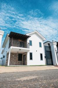 a white house with a balcony on a street at Amber in Tema