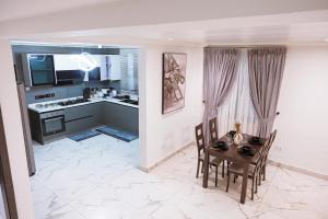 a kitchen and dining room with a table and chairs at Amber in Tema