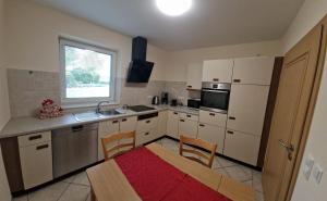 a kitchen with white appliances and a table and chairs at Gartentraum in Papenburg