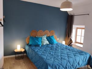 a blue bedroom with a bed with blue pillows at Chambres d'hôtes du Chênelong Cantal in Marchastel