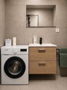 a laundry room with a washing machine and a sink at Apartmán centrum BB s balkónom a parkovaním in Banská Bystrica