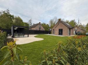 a house with a pavilion in the middle of a yard at Vakantiehuis 6 personen ENL Boutique 92 in Ewijk