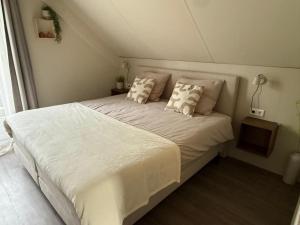 a bedroom with a large white bed with pillows at Vakantiehuis 6 personen ENL Boutique 92 in Ewijk