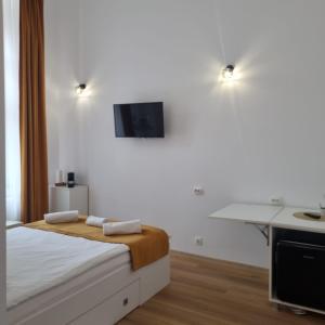 a bedroom with a bed with a tv on the wall at Studio Piata Mare Mardomi in Sibiu