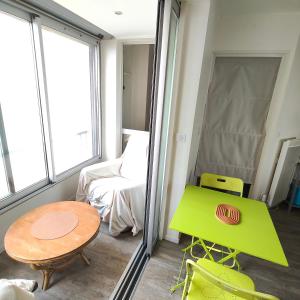 a small room with a green table and a couch at Beach 50 m , vue mer in Carnon-Plage +40 photos