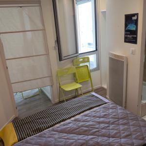 a room with two chairs and a bed and a window at Beach 50 m , vue mer in Carnon-Plage