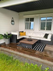 a patio with a white couch and a coffee table at Vetlebekken Apartment close to Trolltunga in Steinaberg