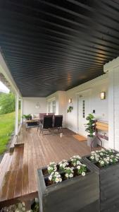 a porch with a wooden deck with a table and chairs at Vetlebekken Apartment close to Trolltunga in Steinaberg