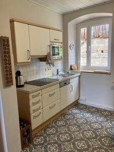 a kitchen with a sink and a microwave at Ferienhaus Alter Hof in Volkach +10 photos
