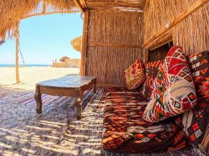 a couch and a table on the beach at Galuma magbul camp in Dahab