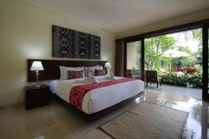 una camera con un grande letto e una grande finestra di Byasa Ubud ad Ubud