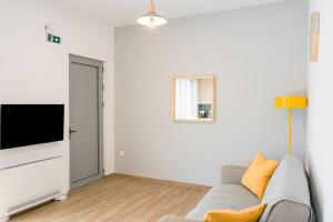 a living room with a couch and a flat screen tv at My Gytheio Apartment in Gythio